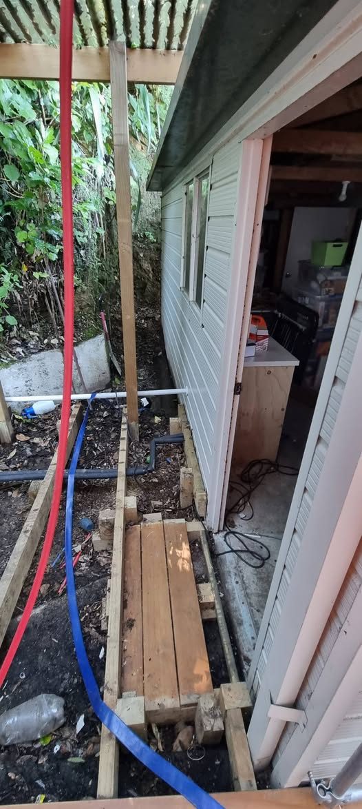 Exposed uPVC drainage pipework trenched alongside a house during a drain repair in Upper Hutt